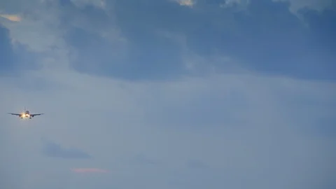 Small jet airplane with head lights is landing during sunset with dark Stock Footage 113572515