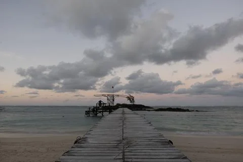 Small jetty or pier with clouds and man silhouetted just after sunset Stock Photos