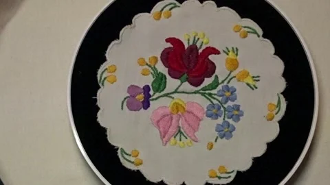 Small Kalocsa embroidered doily rotating slowly on black backgroun Stock Footage 336726493