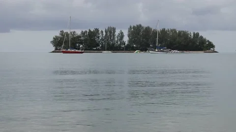 Small keys island ocean bonusing wave water treeline boats Stock Footage 204140951