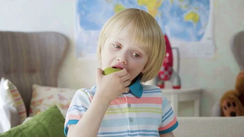Small kid boy bite juicy fresh green apple as a healthy snack wishing to be Stock Footage 77906558