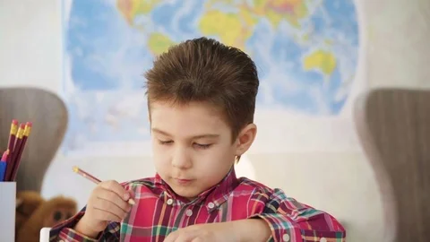 Small kid boy draw with crayons and color pictures on paper with enthusiasm Stock Footage 78199610