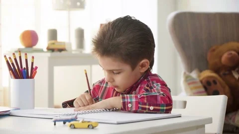 Small kid boy draw with crayons and color pictures on paper with enthusiasm Stock Footage 78199980