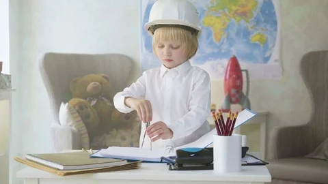 Small kid boy in white helmet imitates constructor working and busy man Stock Footage 77989810