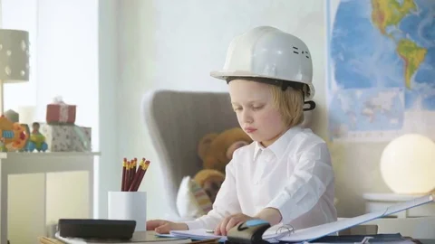 Small kid boy in white helmet imitates constructor working and busy man Stock Footage 77993137
