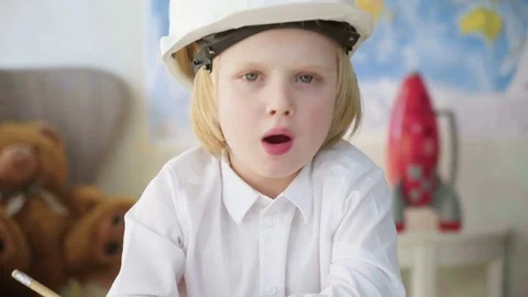 Small kid boy in white helmet imitates constructor working and busy man Stock Footage 78058148