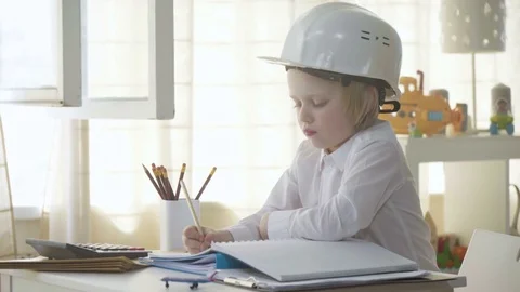 Small kid boy in white helmet imitates constructor working and busy man Stock Footage 78058471