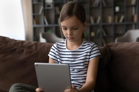 Small kid girl using digital computer tablet. Stock Photos