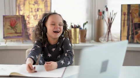 Small kid in headphones using laptop and laughing Stock Footage 150590109