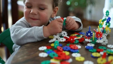 Small kid looks absorbed while playing with colorful blocks 스톡 동영상 75150912