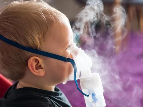 Small kid making inhalation 库存照片