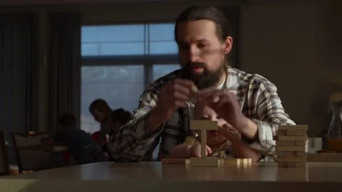 Small Kid newborn with Dad playing tiny jenga her parents at table, jenga tower Stock Footage 172381934