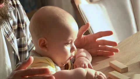 Small Kid newborn with Dad playing tiny jenga her parents at table, jenga tower Video stock 172455592