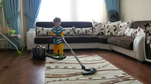 Small kid playing cleaning vacuum machine at home Video stock 76523368