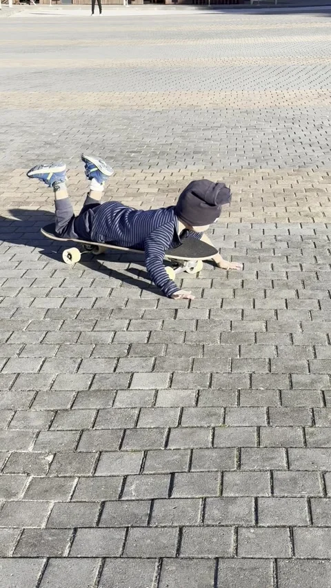 Small kid playing with a skate at Ribeira d Ilhas beach Ericeira on winter Stock Footage 304883101