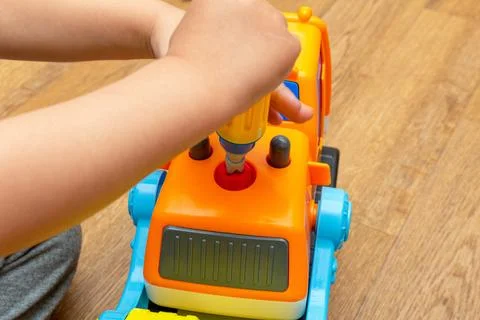 Small kid playing with toy constructor tractor close up Stock Photos