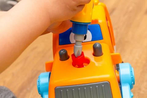 Small kid playing with toy constructor tractor close up Stock Photos