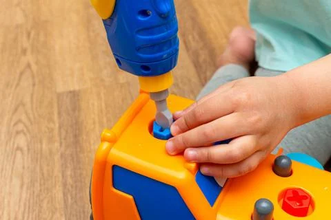Small kid playing with toy constructor tractor close up Stock Photos