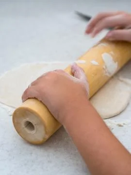 Small kid rolling dough Stock-Fotos