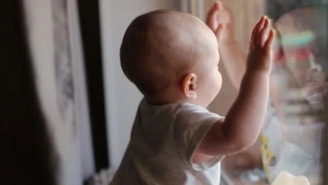 A small kid in a Santa class is looking out the window and hitting the glass Stock Footage 146214173