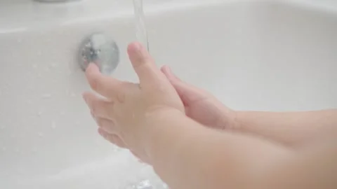 Small kid wash hands with soap over the sink with water COVID-19. Close-up Stock Footage 130413281