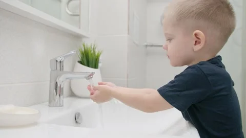 Small kid wash hands with soap over the sink with running water COVID-19 Stock Footage 130413767