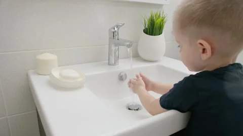Small kid wash hands with soap over the sink with running water COVID-19 Stock Footage 130415417
