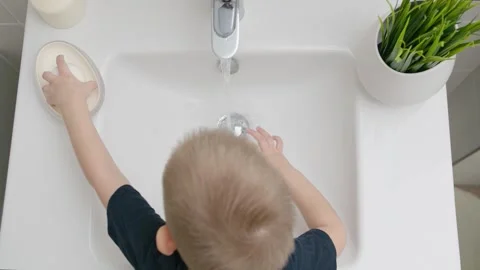 Small Kid washes hands with soap over the sink. Protection against COVID-19 Stock Footage 130418279