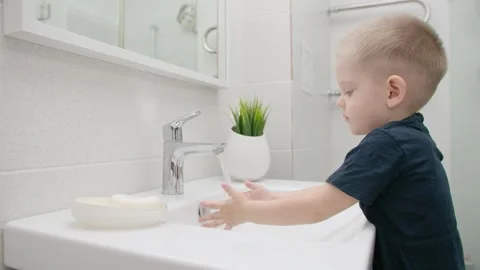 Small Kid washes hands with soap over the sink. Protection against COVID-19 Stock Footage 130418913