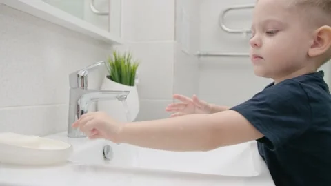 Small Kid washes hands with soap over the sink. Protection against COVID-19 Stock Footage 130419173