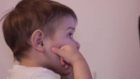 Small kid is watching cartoons at the computer at home Stock Footage 148526824