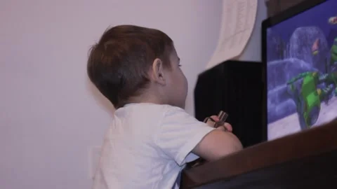 Small kid is watching cartoons at the computer at home Stock Footage 148526996