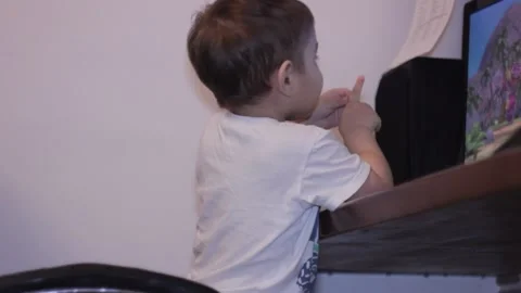 Small kid is watching cartoons at the computer at home Stock Footage 148527036