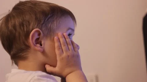 Small kid is watching cartoons at the computer at home Stock Footage 148527070