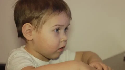 Small kid is watching cartoons at the computer at home Vídeos de archivo 148527114