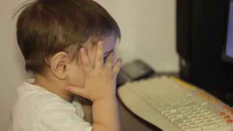 Small kid is watching cartoons at the computer at home Stock Footage 148527116
