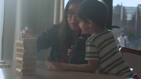 Small Kids Children playing tiny jenga with her parents at table, jenga tower Stock Footage 172381900