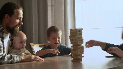 Small Kids Children playing tiny jenga with her parents at table, jenga tower Stock-Footage 172381970