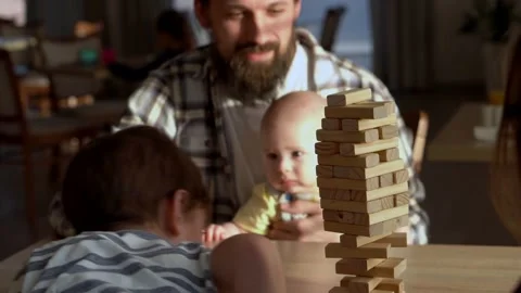 Small Kids Children playing tiny jenga with her parents at table, jenga tower Stock Footage 172382231