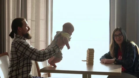 Small Kids Children playing tiny jenga with her parents at table, jenga tower Stock Footage 172382383