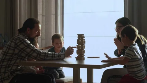 Small Kids Children playing tiny jenga with her parents at table, jenga tower Stock Footage 172382450