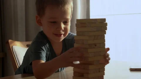 Small Kids Children playing tiny jenga with her parents at table, jenga tower Stock Footage 172382515