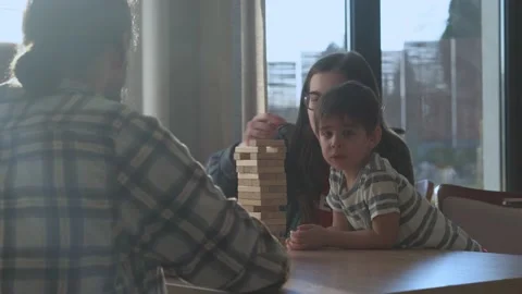 Small Kids Children playing tiny jenga with her parents at table, jenga tower Stock Footage 172382546