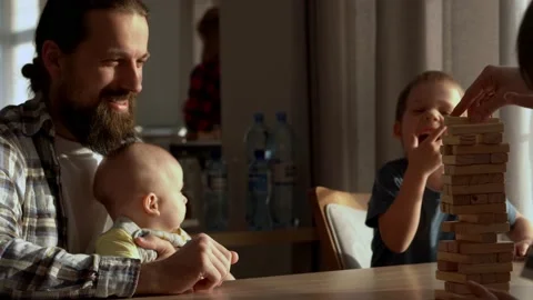 Small Kids Children playing tiny jenga with her parents at table, jenga tower Stock Footage 172382598