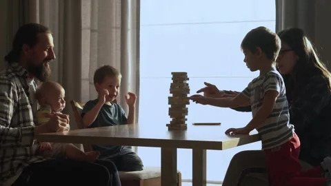 Small Kids Children playing tiny jenga with her parents at table, jenga tower Stock Footage 172419156