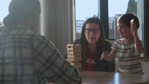 Small Kids Children playing tiny jenga with her parents at table, jenga tower Stock Footage 172455448