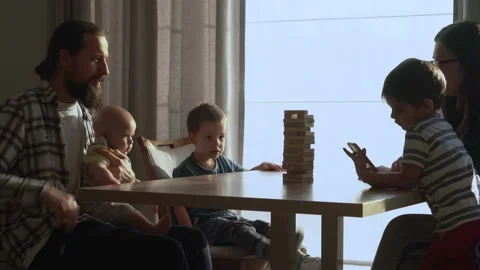 Small Kids Children playing tiny jenga with her parents at table, jenga tower Stock Footage 172456060