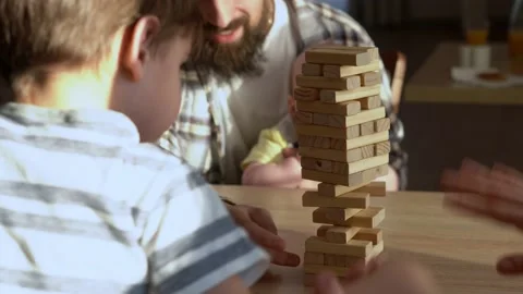 Small Kids Children playing tiny jenga with her parents at table, jenga tower Stock Footage 172505130
