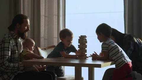 Small Kids Children playing tiny jenga with her parents at table, jenga tower Stock Footage 172505241