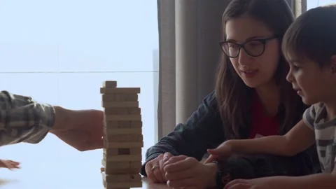 Small Kids Children playing tiny jenga with her parents at table, jenga tower Stock Footage 172552729
